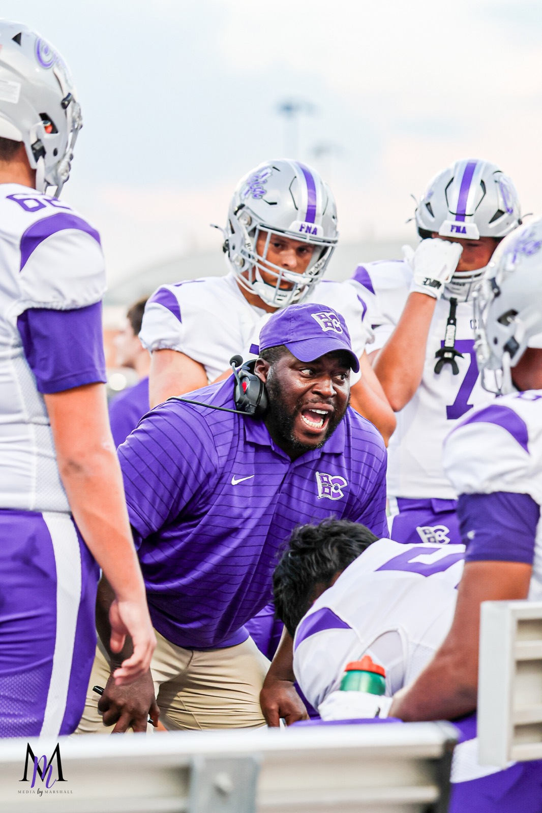 Defensive coaches fire up the defensive linemen along the bench at Turner Stadium