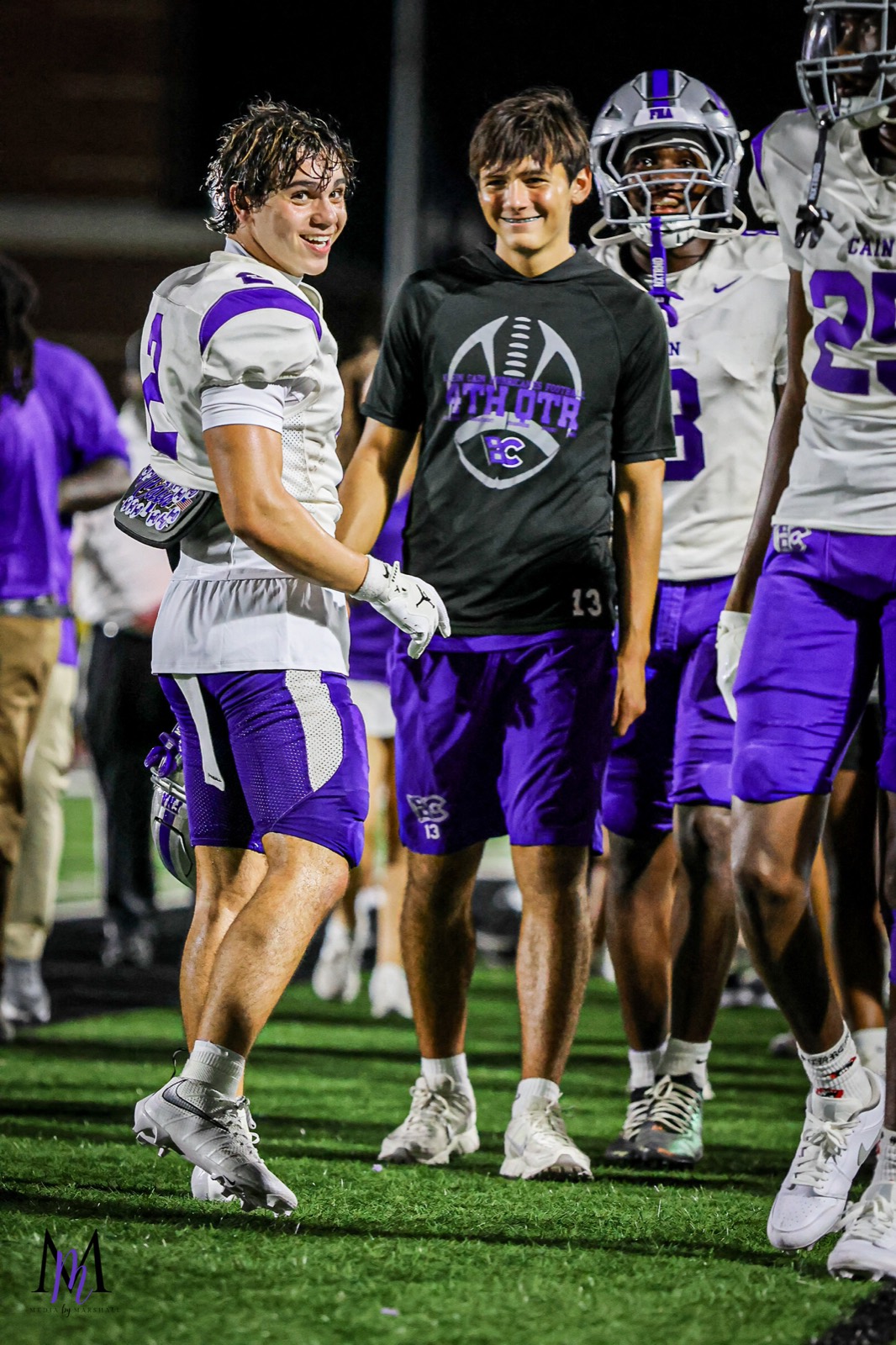 Senior defensive back Michael Elhindi and teammates smile along the sideline
