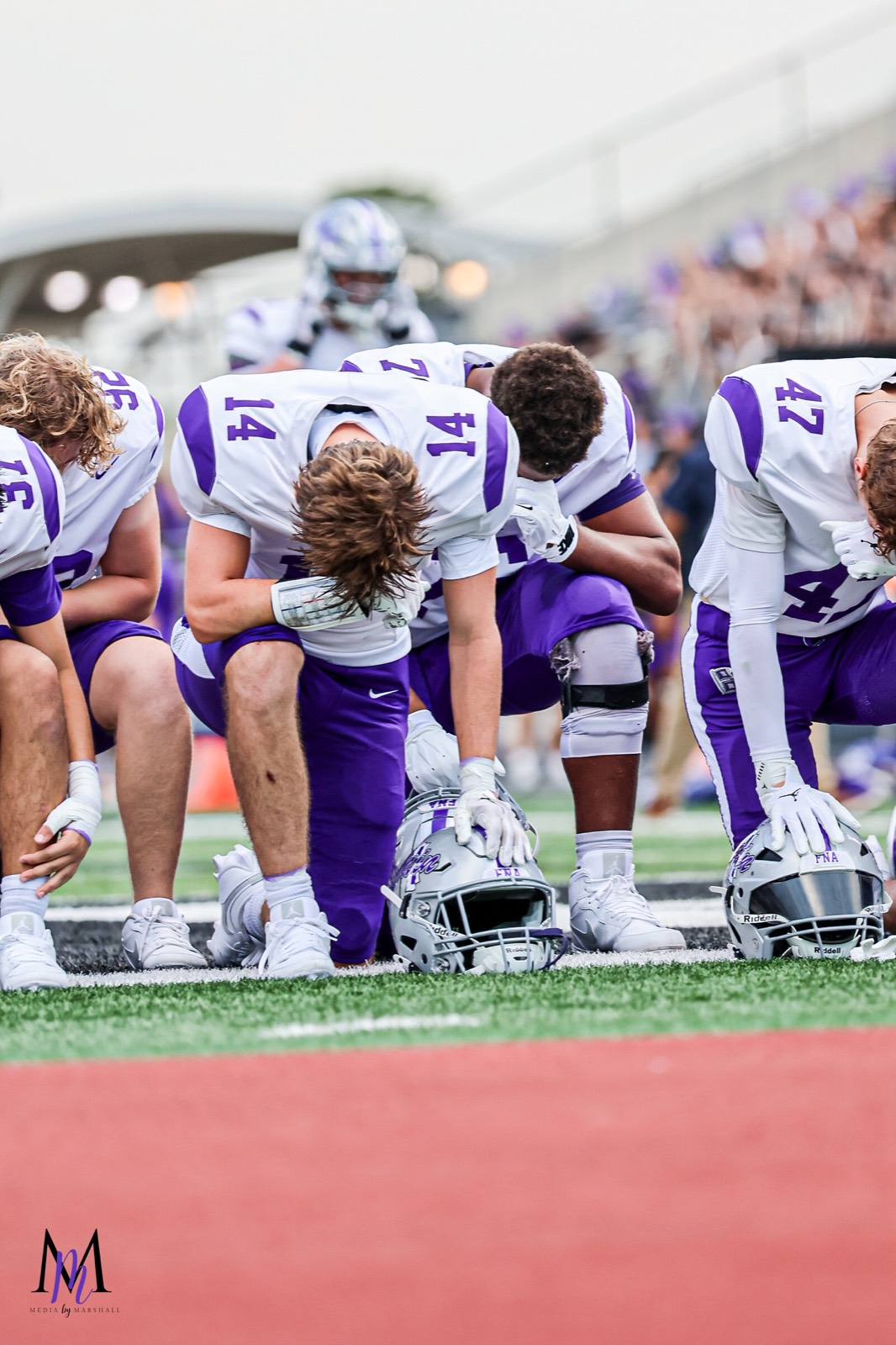 Senior linebacker Gage Hansberger, senior defensive back Matthew Eiermann, and junior safety Easton Mizell bow their heads in pregame prayer
