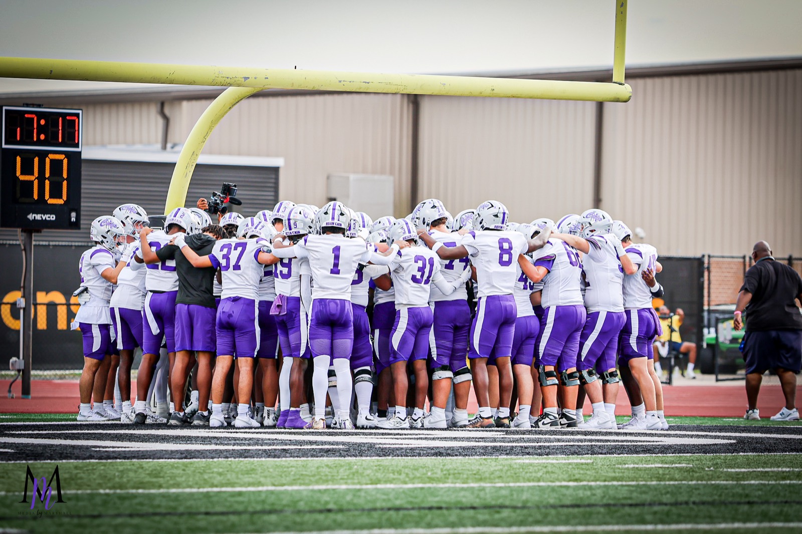 The Klein Cain Hurricanes gather in a pregame team huddle in the end zone before kickoff