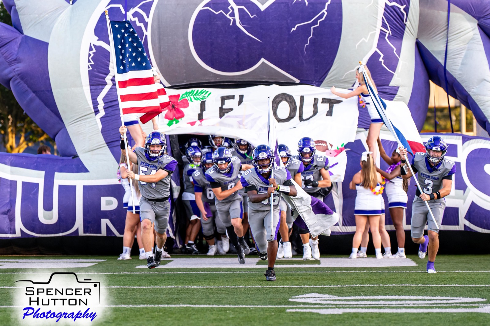 Senior tight end Wes Young carries the Texas flag leading the Klein Cain Hurricanes out of the helmet tunnel