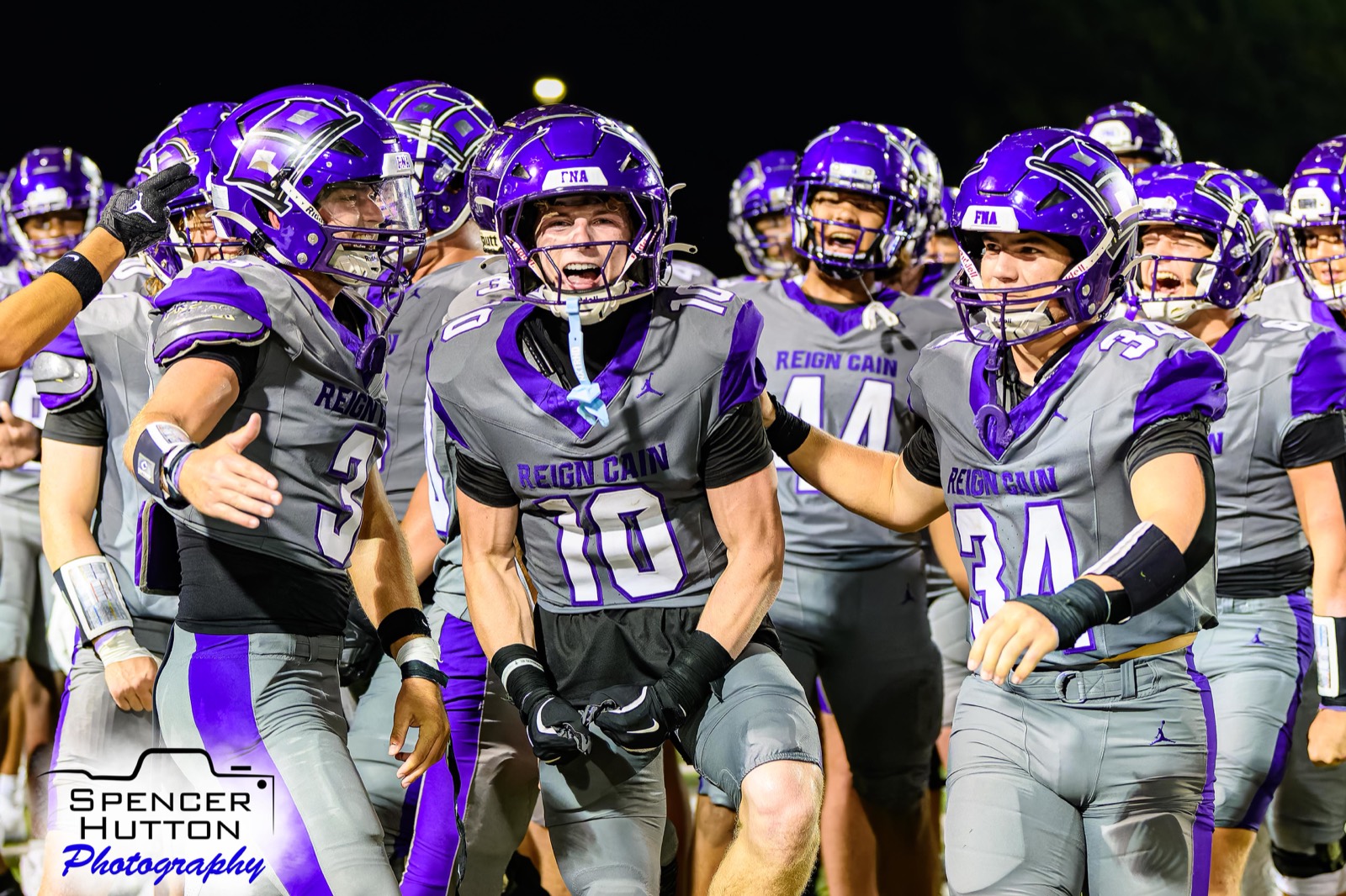 Senior wide receiver Cooper Karns flexes in celebration with tight end Wes Young and linebacker Gage Hansberger