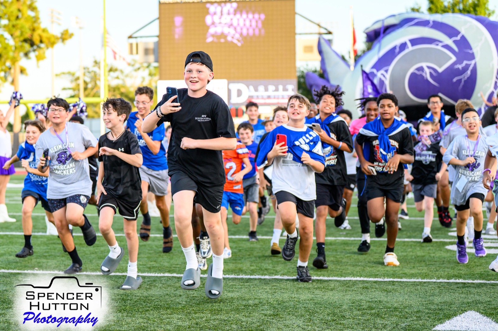 Future Hurricane Night youth runners race across the field at Klein Memorial Stadium before kickoff